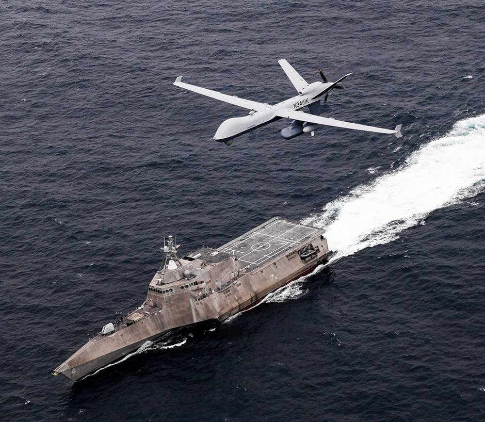 A contractor-operated MQ-9B SeaGuardian, a maritime operations optimized variant of the MQ-9 Reaper, flies over the U.S. Navy's <em>Independence</em> class Littoral Combat Ship (LCS) USS <em>Coronado</em> during an exercise in 2021. <em>USN</em>