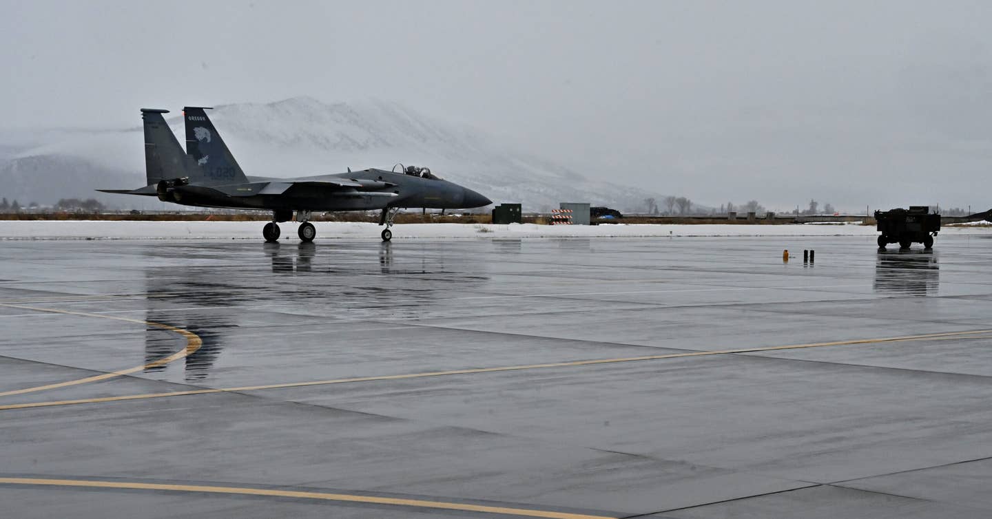 Capt. Andrew Marshall taxis his F-15C across a rainswept tarmac before taking off to nearby range space for upgrade training, on January 18, 2024, at Kingsley Field in Klamath Falls, Oregon. <em>U.S. Air National Guard photo by Master Sgt. Jefferson Thompson</em>