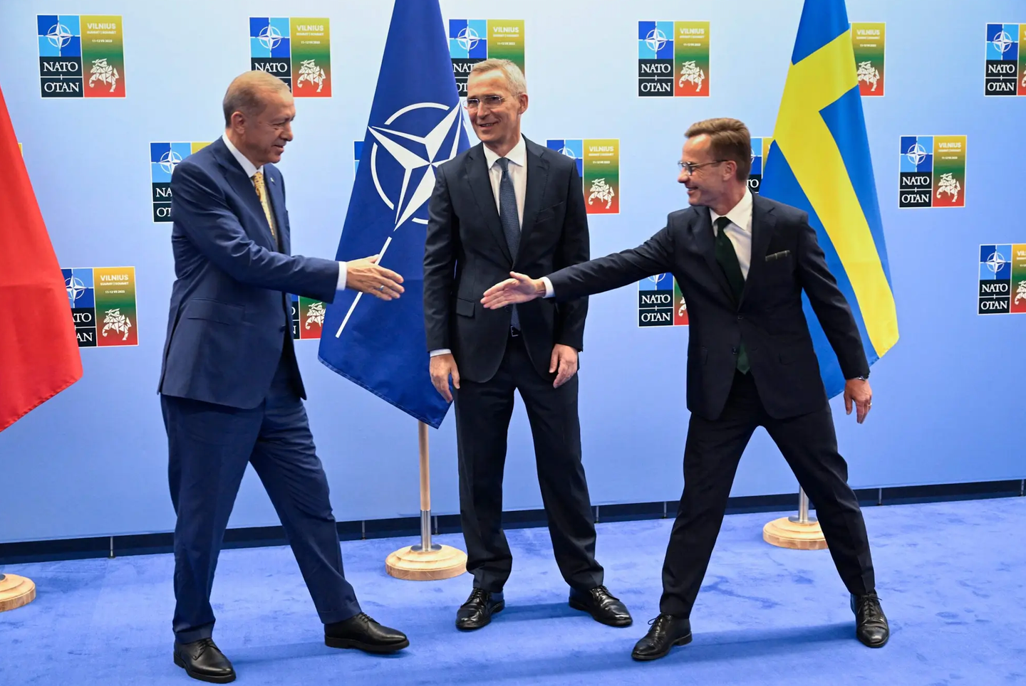 Turkish President Tayyip Erdogan (left) and Swedish Prime Minister Ulf Kristersson shake hands next to NATO Secretary-General Jens Stoltenberg before a meeting on the eve of a NATO summit, in Vilnius on July 10, 2023. <em>Photo by HENRIK MONTGOMERY/TT NEWS AGENCY/AFP via Getty Images<br></em>
