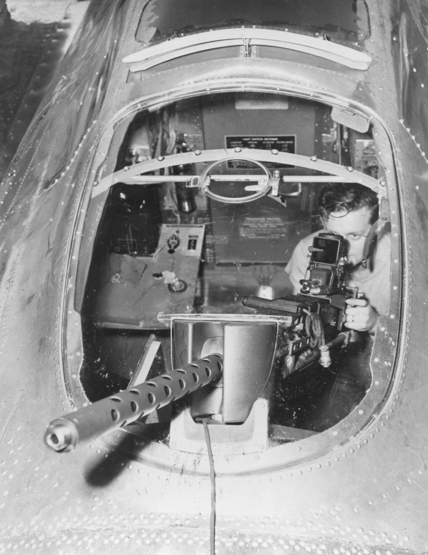 A gunner sights his machine gun through the Plexiglass hood that was introduced over the radio compartment in the upper fuselage, amidships on the B-17, in a photo dated September 1944. <em>Photo by PhotoQuest/Getty Images</em>