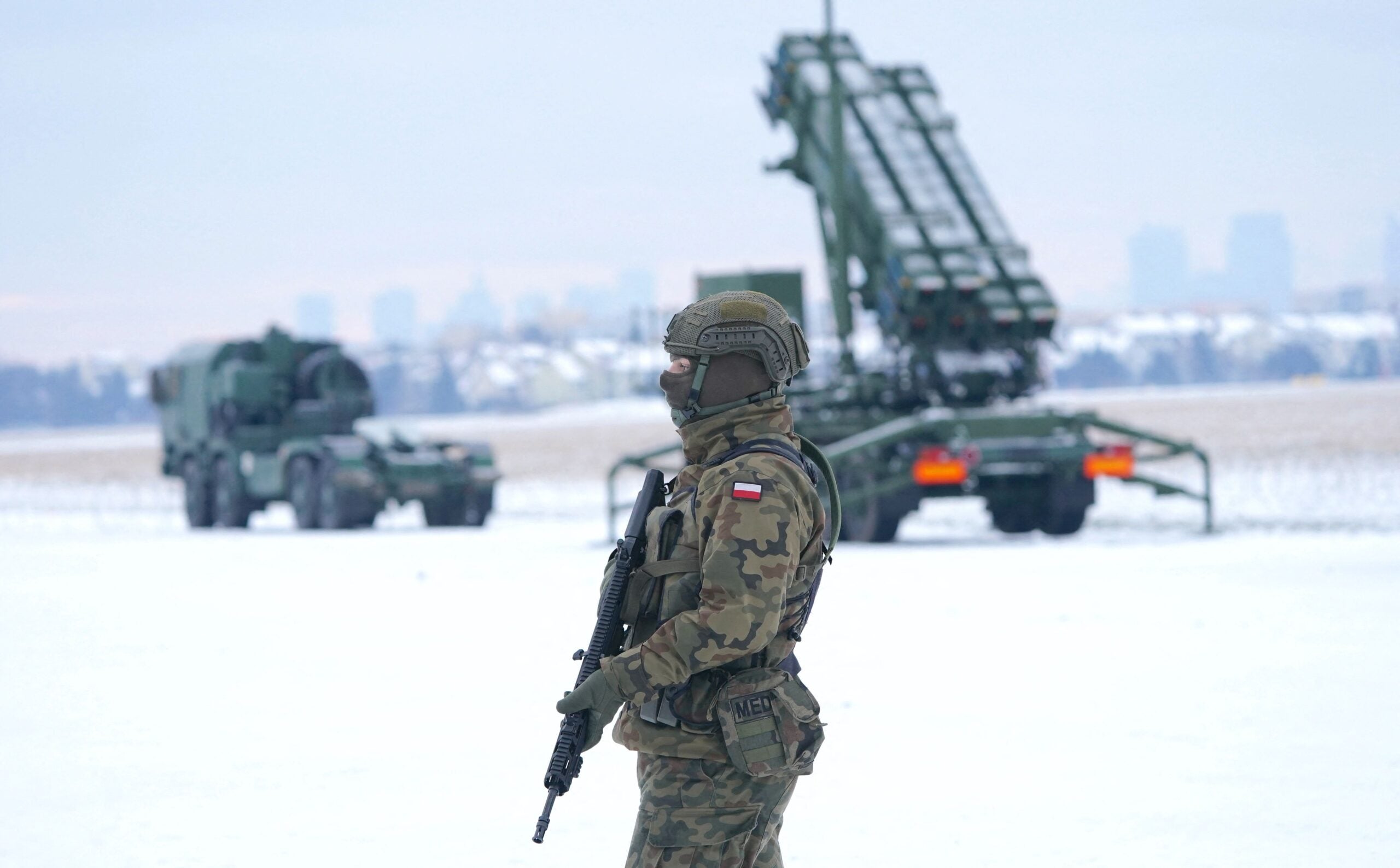 A soldier stands in front of a PATRIOT (Phased Array Tracking Radar to Intercept on Target) surface-to-air missile system during a military exercise at Warsaw Babice Airport, Poland on February 7, 2023. - Patriot missile systems purchased by Poland last year have been redeployed to the Polish captital for military exercises. (Photo by JANEK SKARZYNSKI / AFP) (Photo by JANEK SKARZYNSKI/AFP via Getty Images)