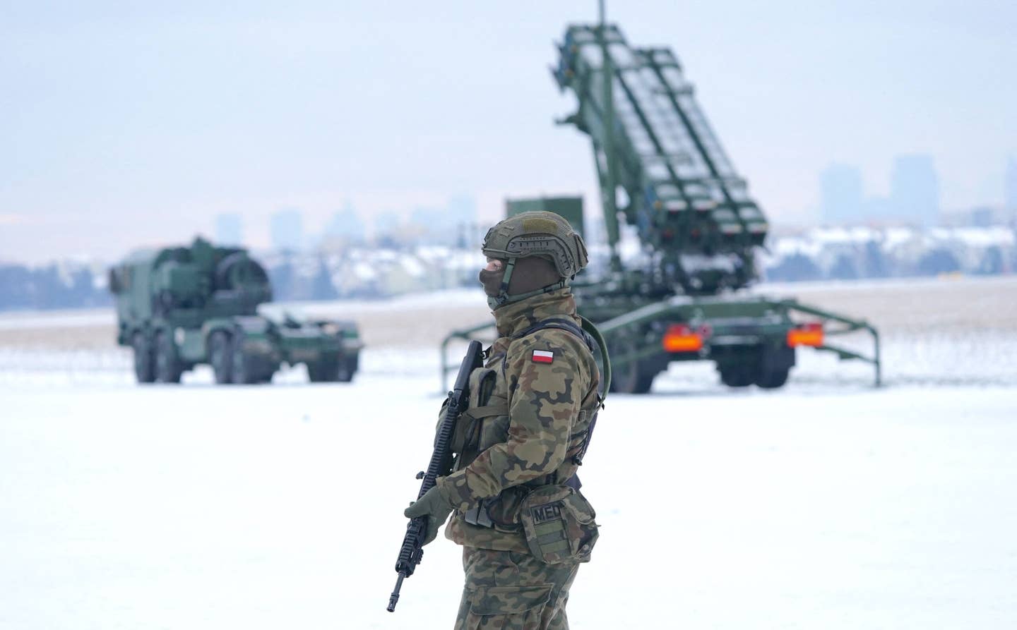 A Polish soldier stands in front of a Patriot air defense system deployed during a military exercise at Warsaw Babice Airport, Poland, on February 7, 2023. <em>Photo by JANEK SKARZYNSKI/AFP via Getty Images</em>
