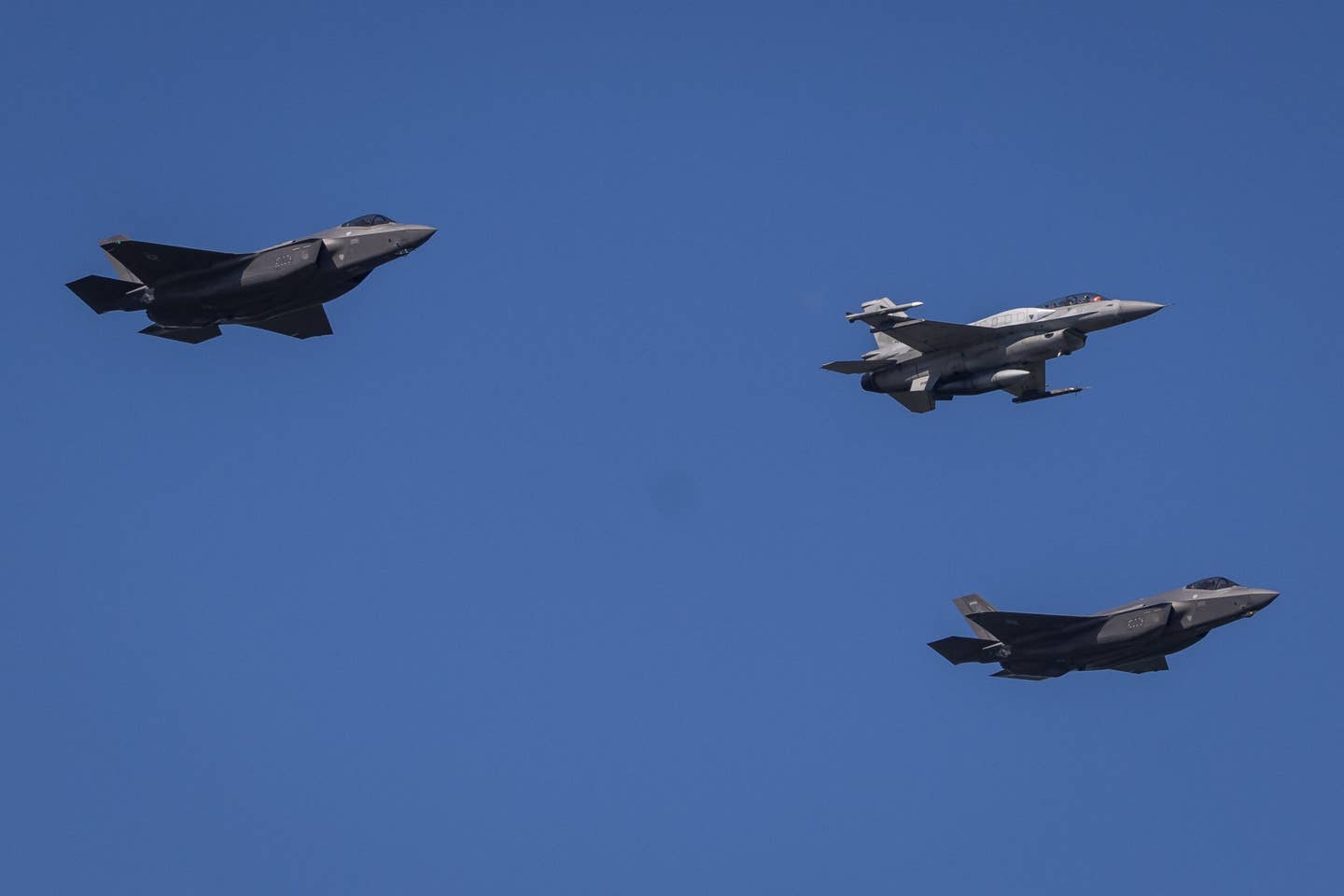 Two U.S. Air Force F-35s and a Polish Air Force F-16 take part in a military parade in Warsaw on Polish Army Day, August 15, 2023, to commemorate the anniversary of the 1920 victory over Soviet Russia at the Battle of Warsaw during the Polish-Soviet War. <em>Photo by WOJTEK RADWANSKI/AFP via Getty Images</em>