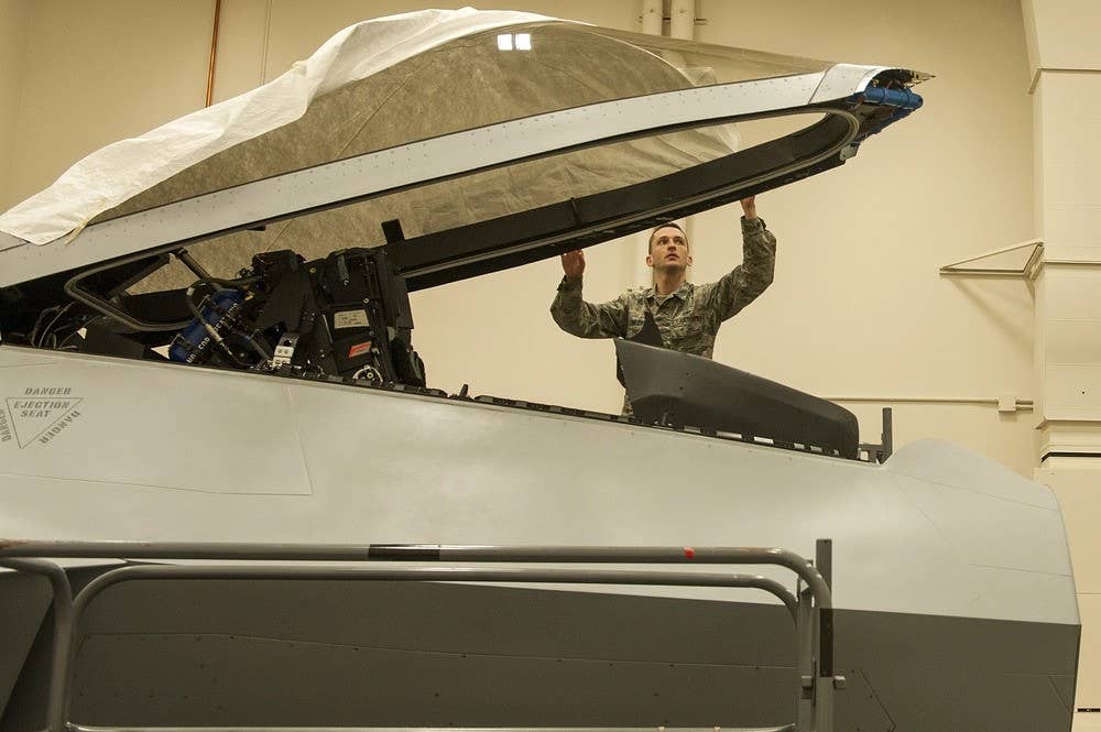 U.S. Air Force Tech. Sgt. Jeremy Finley, F-22 Raptor crew chief instructor at the 372nd Training Squadron, Detachment 14, prepares the canopy of an F-22 Raptor simulator at Joint Base Elmendorf-Richardson. Det. 14 is part of the Air Education and Training Command's 82nd Training Wing out of Sheppard Air Force Base in Wichita Falls, Texas. (U.S. Air Force photo by Staff Sgt. James Richardson)