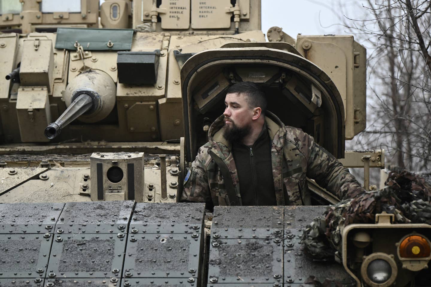 A Ukrainian serviceman of the 47th Mechanized Brigade prepares for combat in an M2 Bradley infantry fighting vehicle, not far away from Avdiivka, on February 11, 2024. <em>Photo by Genya SAVILOV / AFP</em>