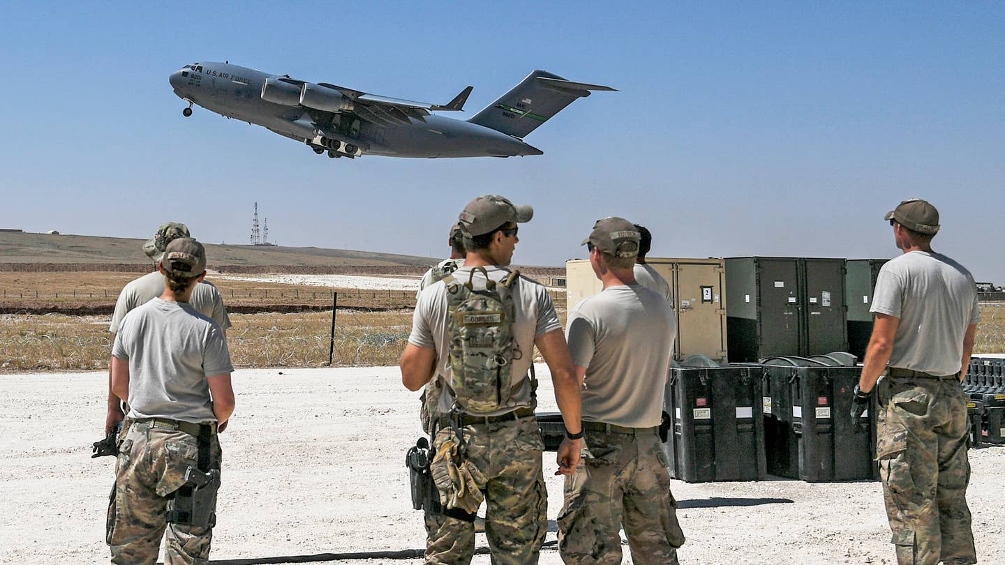 U.S. Air Force Airmen assigned to the 727th Expeditionary Air Control Squadron (EACS) and U.S. Air Forces Central Command Communication Directorate (A6) view a U.S. Air Force C-17 Globemaster takeoff from an austere runway at a Coalition airfield in Northeast Syria, June 25, 2018. (U.S. Air Force photo by Staff Sgt. Corey Hook)
