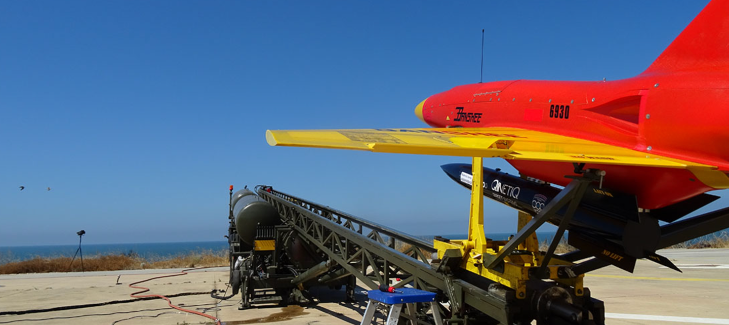 A Banshee on its catapult launcher. This example carries QinetiQ’s&nbsp;<a href="https://www.aerospacetestinginternational.com/news/weapons-testing/qinetiq-reveals-air-launched-uav-supersonic-target.html" target="_blank" rel="noreferrer noopener">Rattler supersonic target drone</a> under the belly, which can in turn be launched from the Banshee.&nbsp;<em>QinetiQ</em>