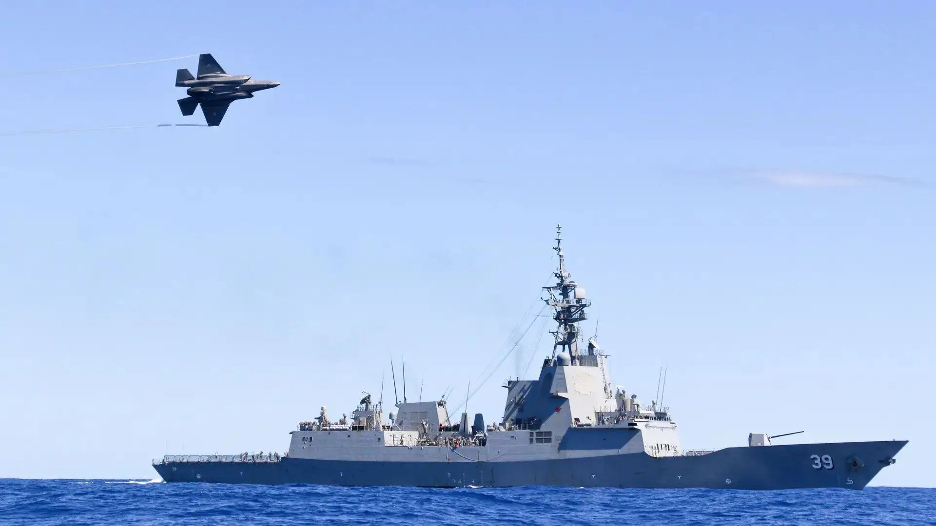 A Royal Australian Air Force F-35A Lightning conducts a flypast over HMAS Hobart during Exercise TASMAN SHIELD 21, off the east coast of Australia. Both these platforms are now set to receive new long-range strike missiles. Australian Department of Defense 