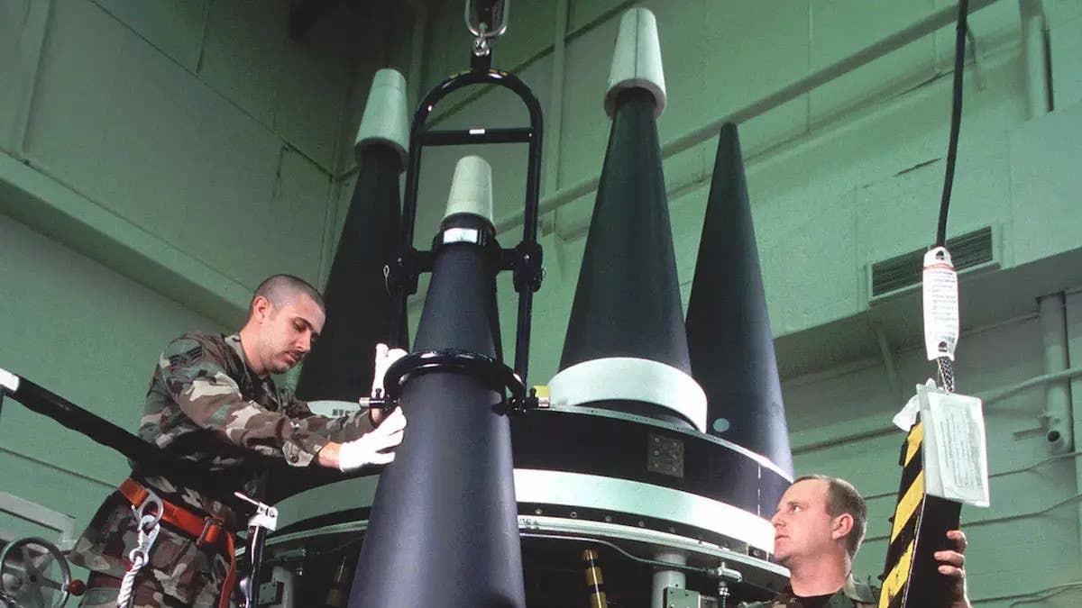 Air Force personnel maneuver reentry vehicles on a payload bus for the Minuteman III ICBM. As a result of arms control agreements, deployed Minuteman III missiles today are loaded with only one warhead. <em>USAF</em>