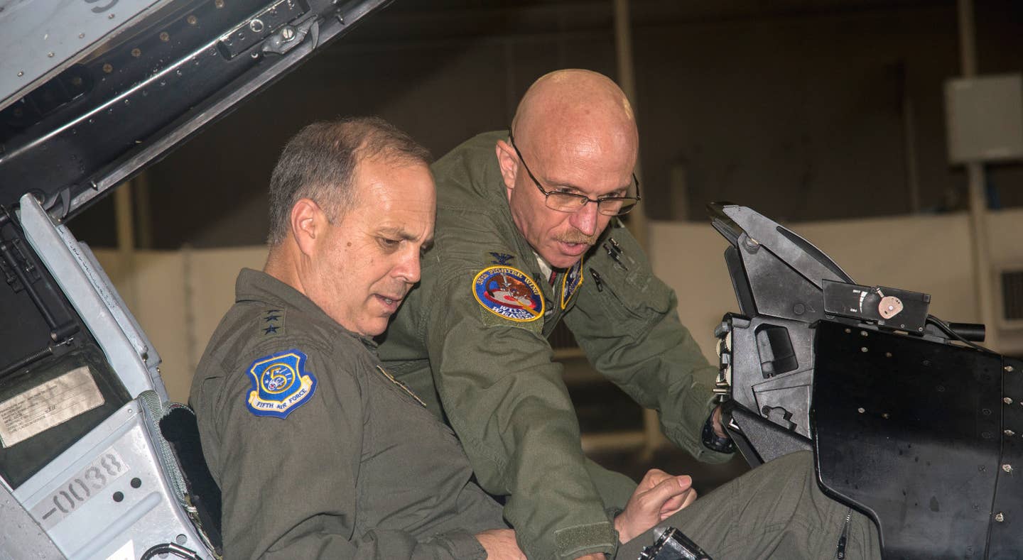 Scott Jobe, at right, then a Colonel in command of the 35th Fighter Wing at Misawa Air Base in Japan, walks Lt. Gen. Jerry P. Martinez, then-U.S. Forces Japan and 5th Air Force commander, through the cockpit of an F-16 Viper fighter in 2017. <em>USAF</em>