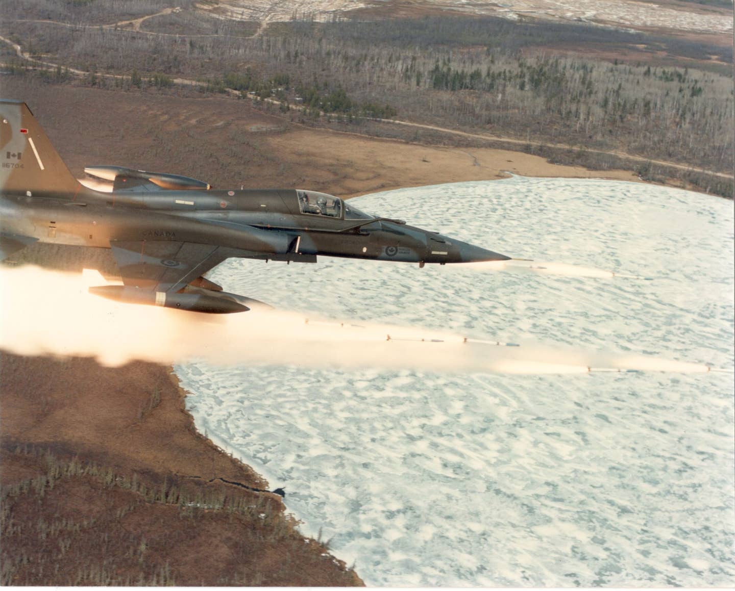 Firing CRV-7 rockets at Jimmy Lake Range, Cold Lake Alberta. The skinny air intake starts below the cockpit, but the engine sits well behind the back of the wing. <em>DND photo.</em>