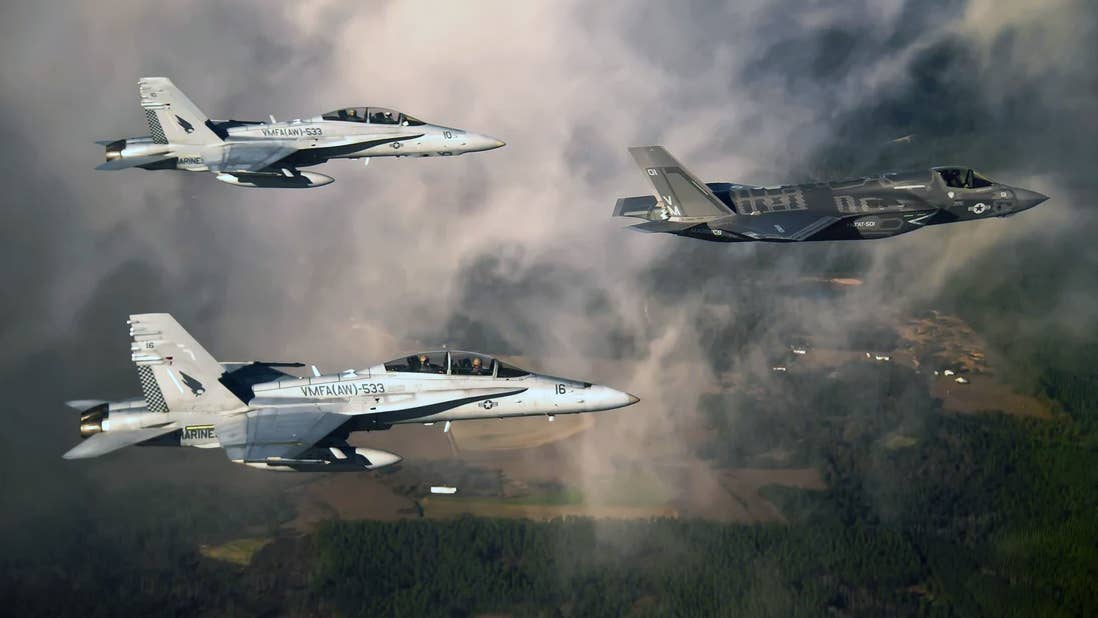 USMC F/A-18Ds fly alongside an F-35B. (DoD Image)