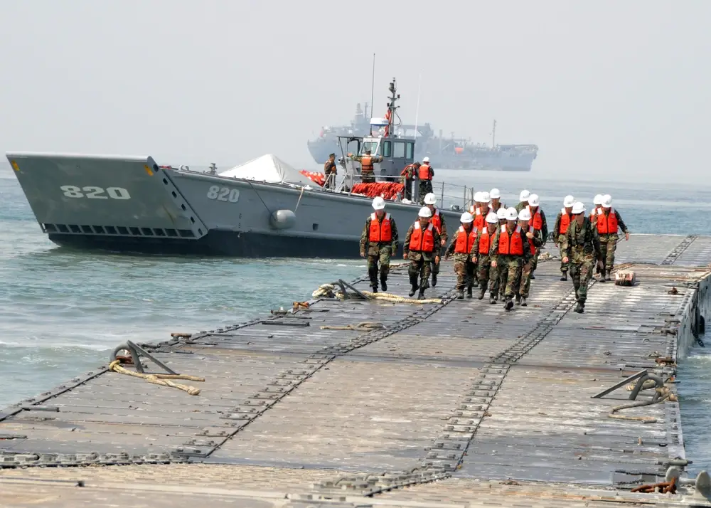 Civil Engineer Corp students take a tour of the Admin Pier as Assault Craft Unit 1 landing craft mechanized departs the pier during Joint Logistics Over-The-Shore 2008. JLOTS 2008 is an engineering, logistical training exercise between Army and Navy units.&nbsp;(U.S. Navy)