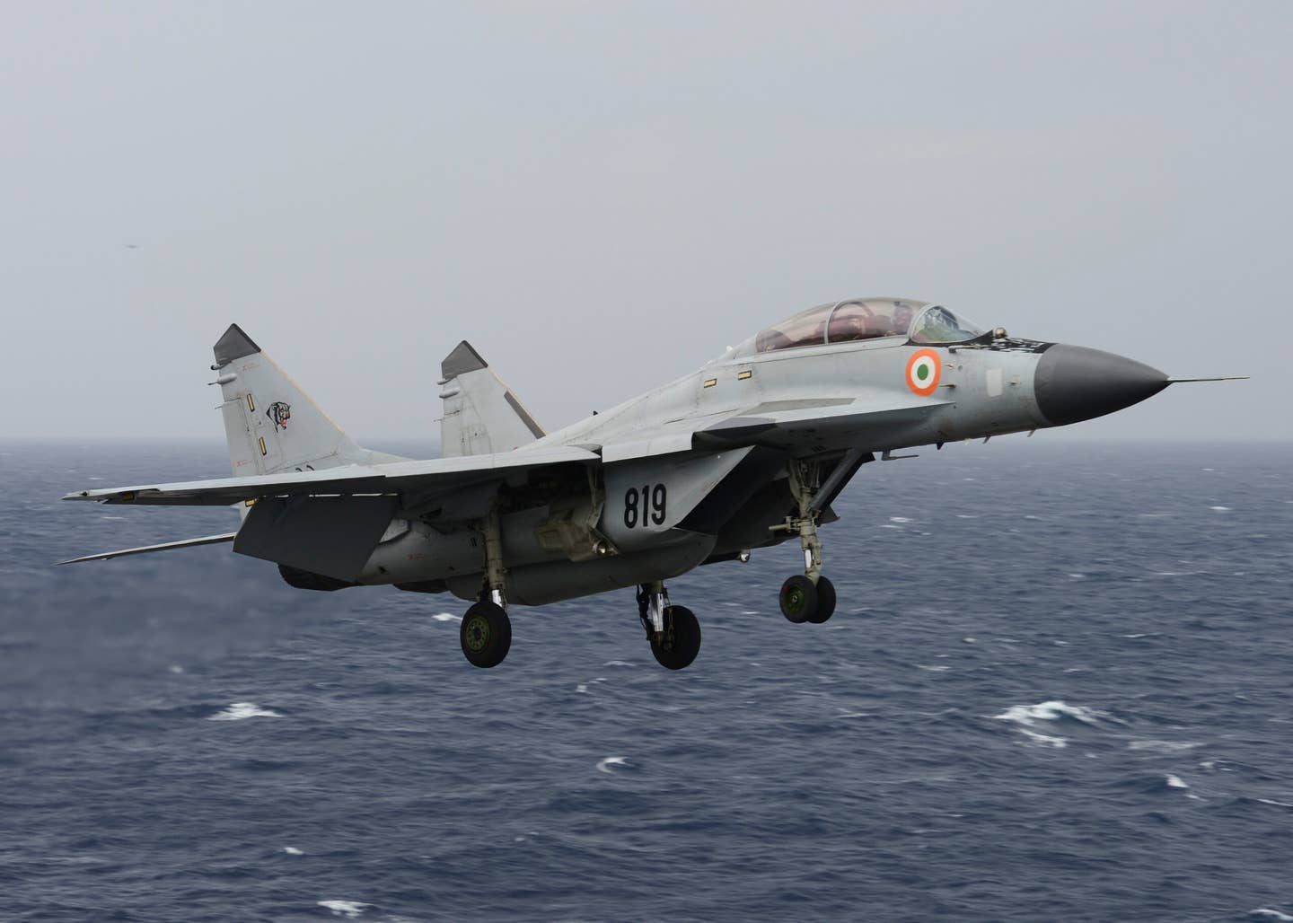 An Indian Navy MiG-29K flies over the aircraft carrier USS <em>Nimitz</em> (CVN-68) during Exercise Malabar 2017. Note the rectangular LEVCONs deployed from the wing root extensions on the approach to the carrier. <em>U.S. Navy photo by Mass Communication Specialist 3rd Class Colby S. Comery/Released</em>