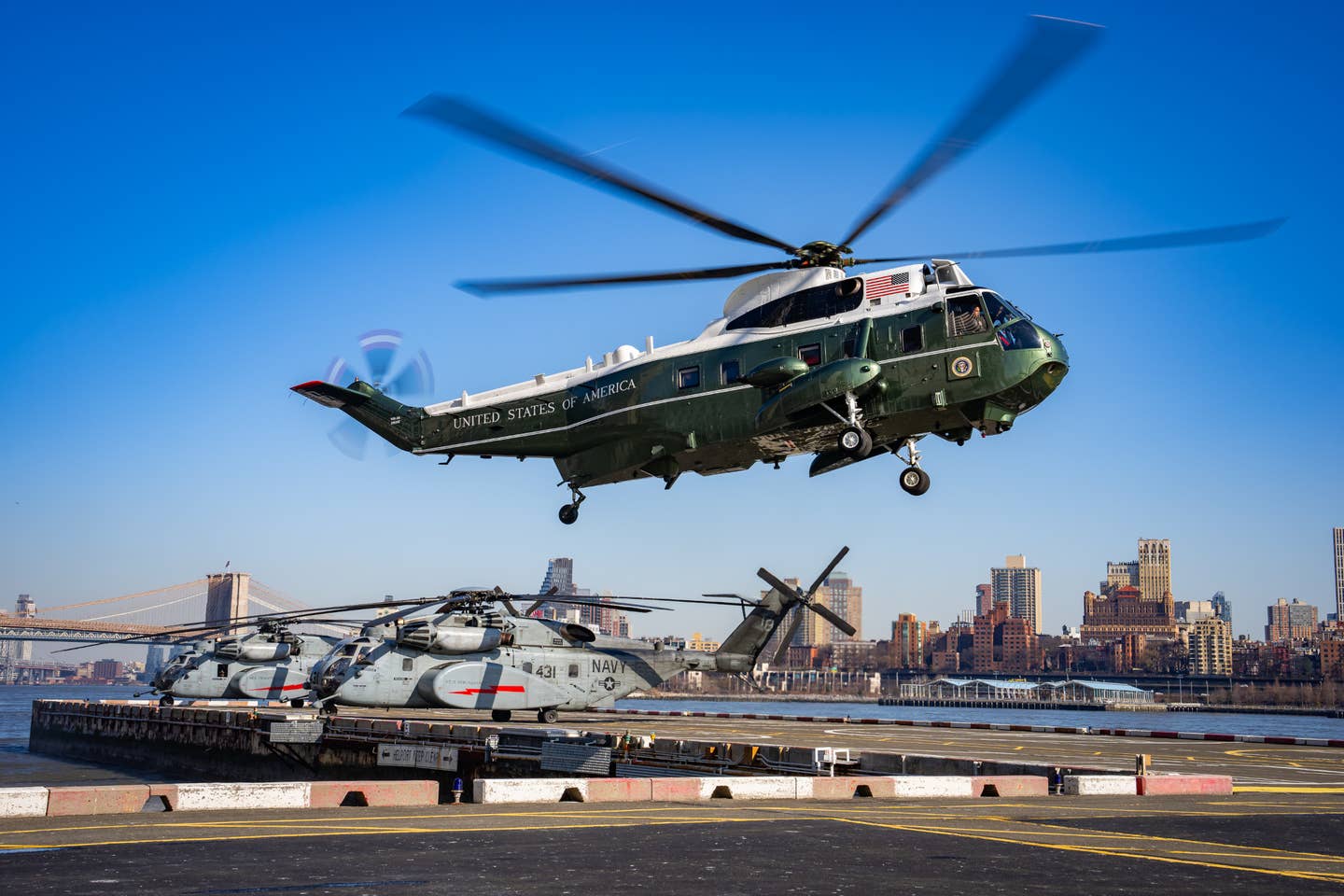 A VH-3D flying Marine One, with President Joe Biden aboard, approaches the Wall Street landing zone in New York City on February 26, 2024. A pair of U.S. Navy MH-53E helicopters are seen behind.<em> White House/Adam Schultz</em>