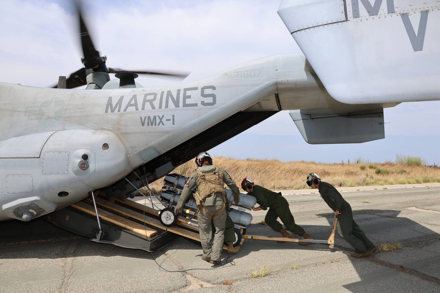 Marines unloading the Small Diameter Bomb II training rounds from the Osprey with the help of a pilot during the exercise. (James Deboer)