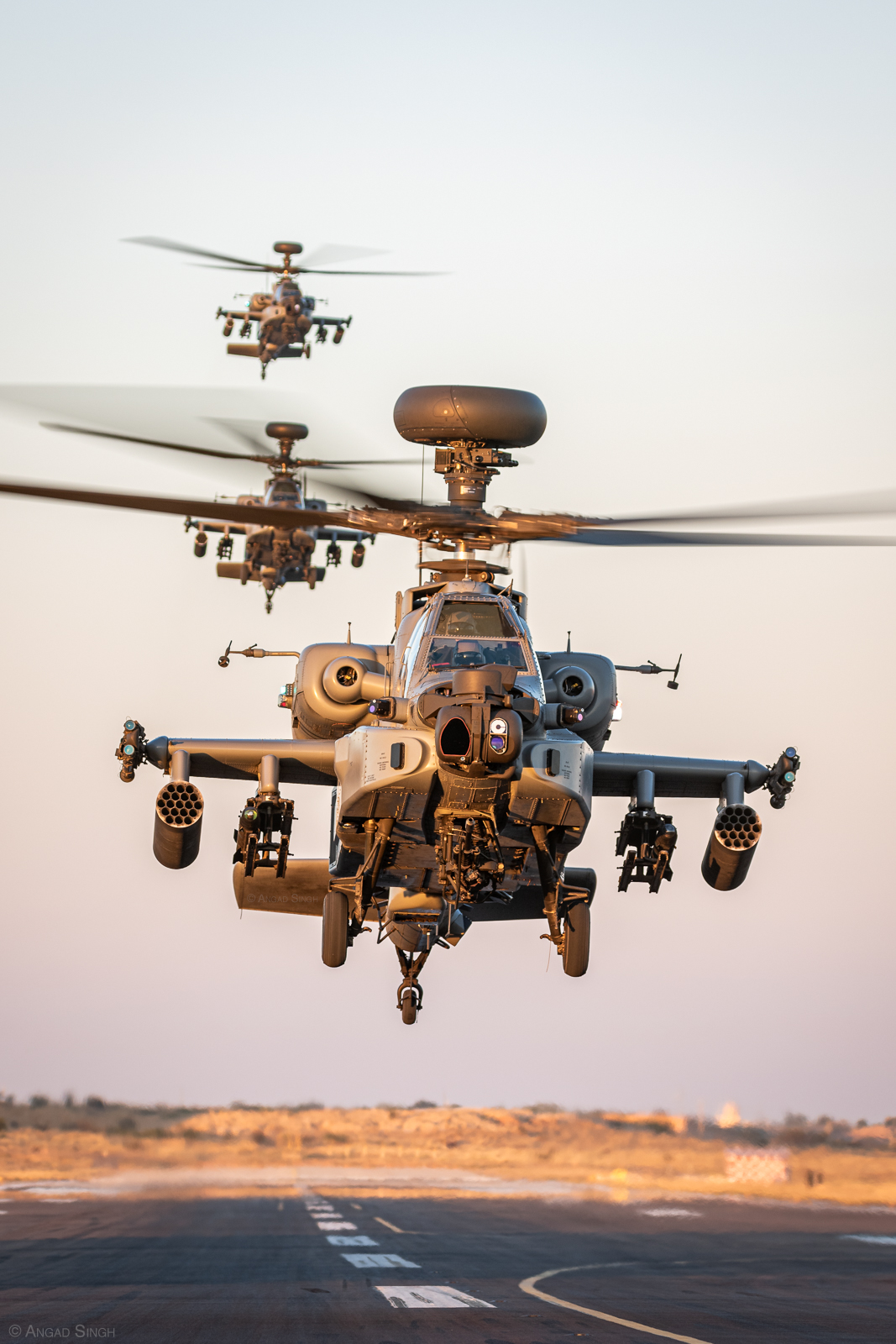 Returning from the range, a trio of AH-64E Apaches stacks up over the runway before touching down. <em>Angad Singh</em>