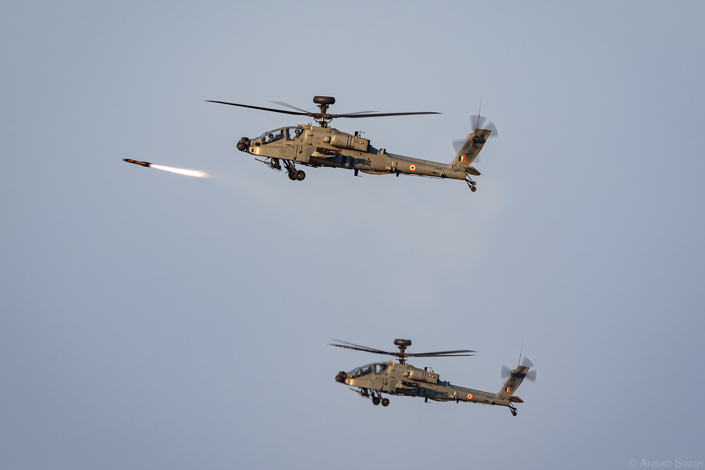 The lead of this pair of AH-64E(I) Apaches fires an AGM-114 Hellfire anti-tank missile. <em>Angad Singh</em>