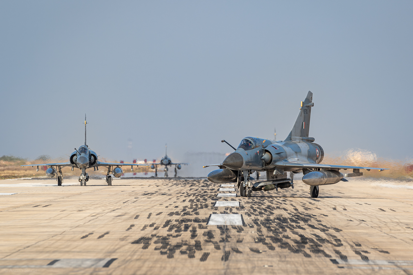 A gaggle of Mirage 2000s loaded with 250-kilogram bombs make their way down the runway for a range mission. <em>Angad Singh</em>