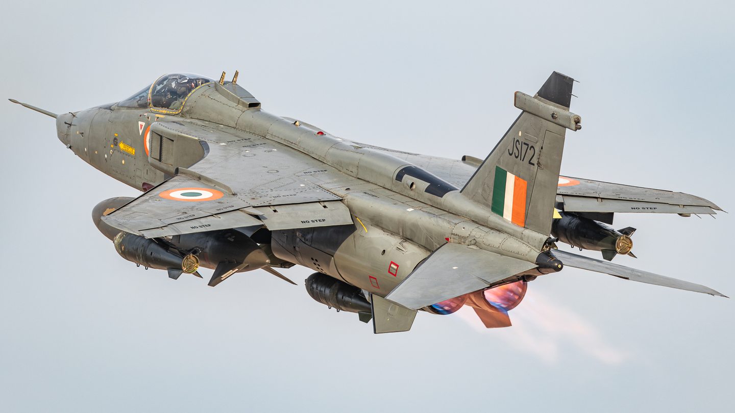 13. A DARIN I Jaguar gets airborne with three 1000-lb parachute retarded bombs and drop tanks still retaining the old two-tone green and grey paint scheme.