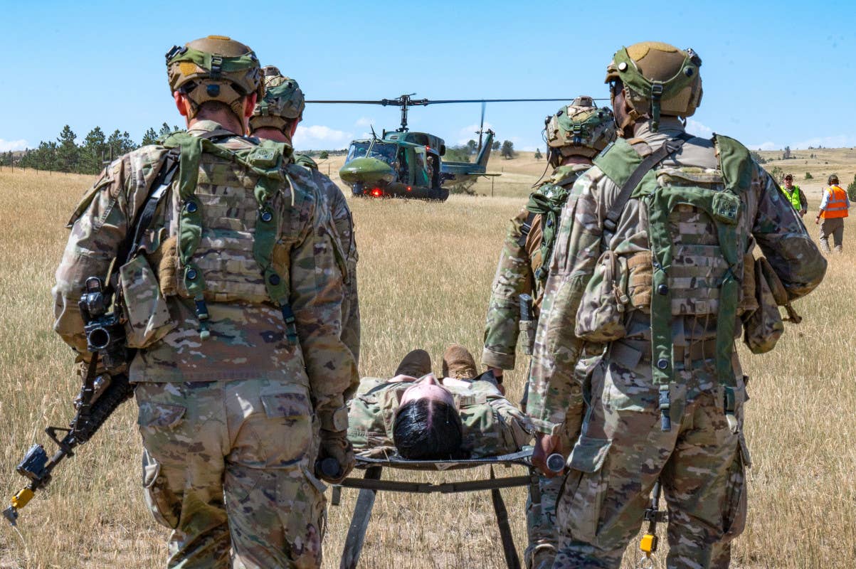 Air Force personnel assigned to AFGSC carry a mock casualty to a UH-1N helicopter during a training exercise. <em>USAF</em>