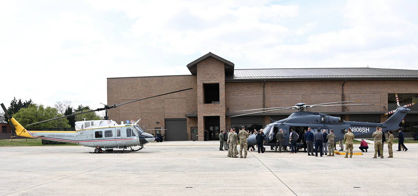 Air Force personnel and others inspect an MH-139A helicopter, at left, at Andrews Air Force Base in 2023. One of the 1st Helicopter Squadron's UH-1Ns is seen at left. <em>USAF</em>