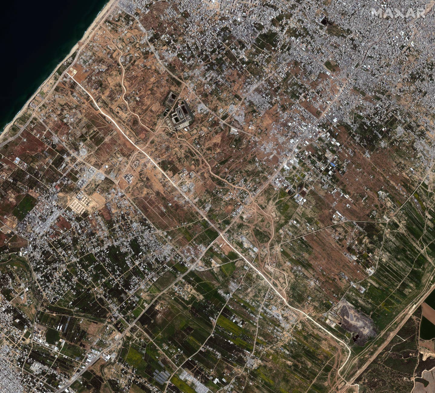 A view of northern Gaza as of March 12. The new Netzarim Road is 'brightly' prominently visible here. The jetty site can be seen just to the northwest of where it ends near the coast. <em>Satellite image ©2024 Maxar Technologies</em>