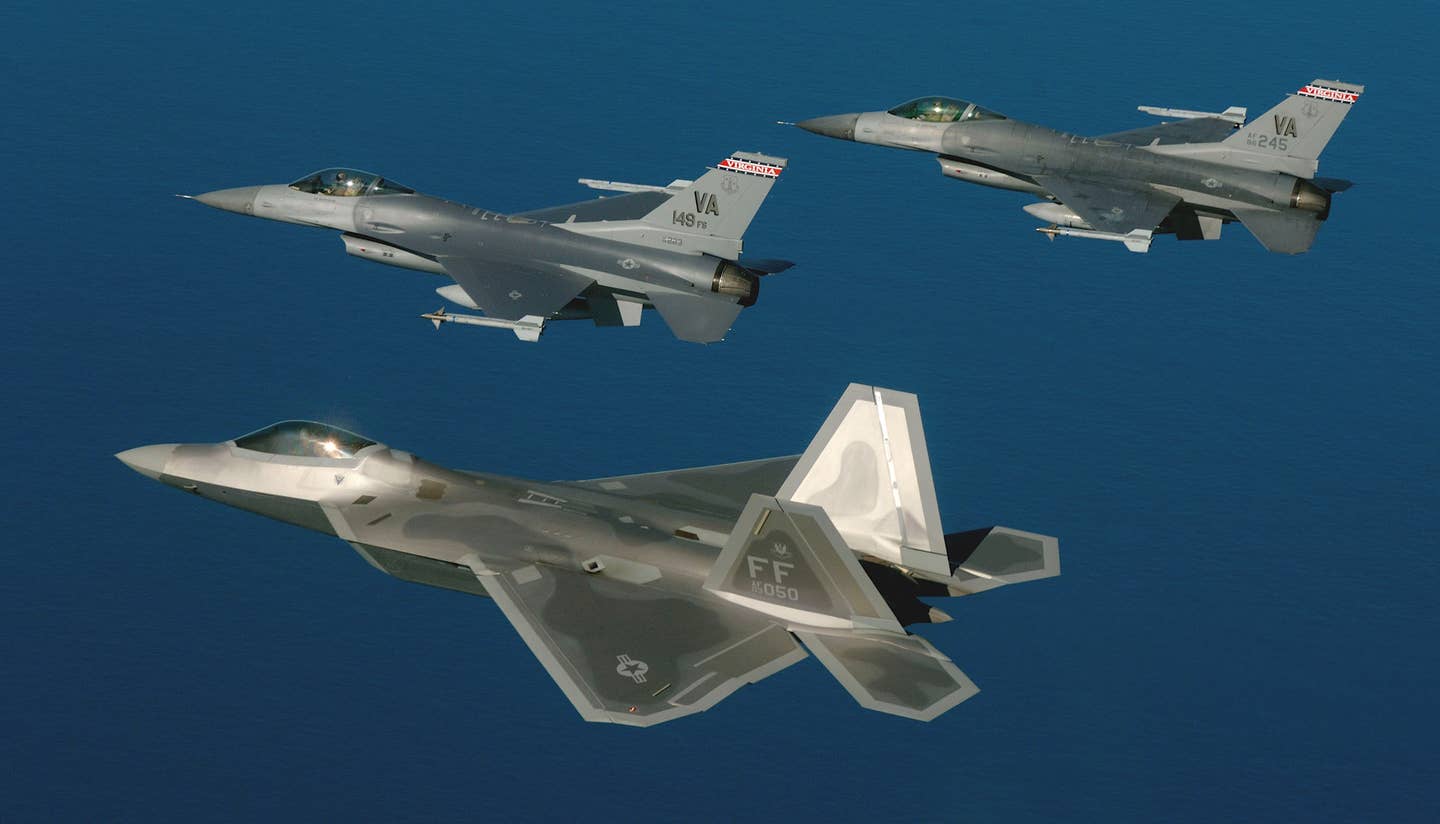 An F-22 Raptor stealth fighter based at Langley Air Force Base, at bottom, flies with a pair of Virginia Air National Guard F-16C fighters during a training mission. <em>USAF</em>