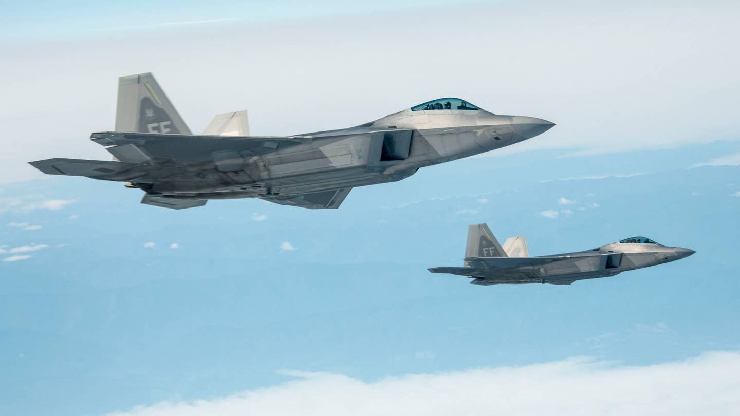 A pair of F-22s from Langley Air Force over Canada's British Colombia province on their way to a NORAD exercise in 2015. <em>USAF</em>
