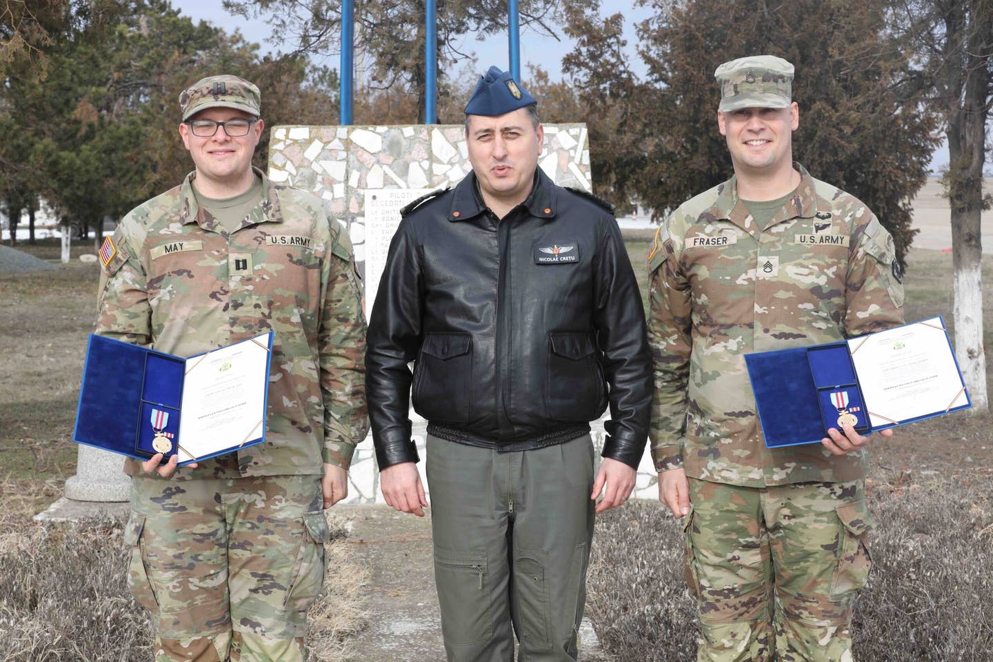 Capt. Jonathan May and Staff Sgt. Derek Fraser, soldiers assigned to the 509 Strategic Signal Battalion, pose for a picture with Col. Nicolae Cretu, the Romanian Air Force 57th Air Base commander, after being presented the Romanian Air Force Emblem of Honor on Mihail Kogalniceanu Air Base, February 7, 2024. <em>U.S. Army Reserve photo by Sgt. Brendon Green-Daring</em>