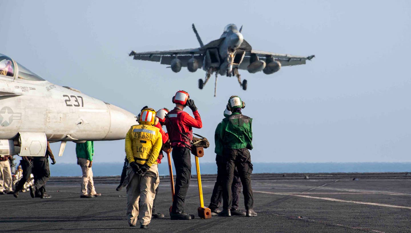 Sailors observe as an F/A-18E Super Hornet lands on the flight deck aboard the Nimitz-class aircraft carrier USS Dwight D. Eisenhower (CVN 69) in the Red Sea, March 12. The Dwight D. Eisenhower Carrier Strike Group is deployed to the U.S. 5th Fleet area of operations to support maritime security and stability in the Middle East region. (Official U.S. Navy photo)