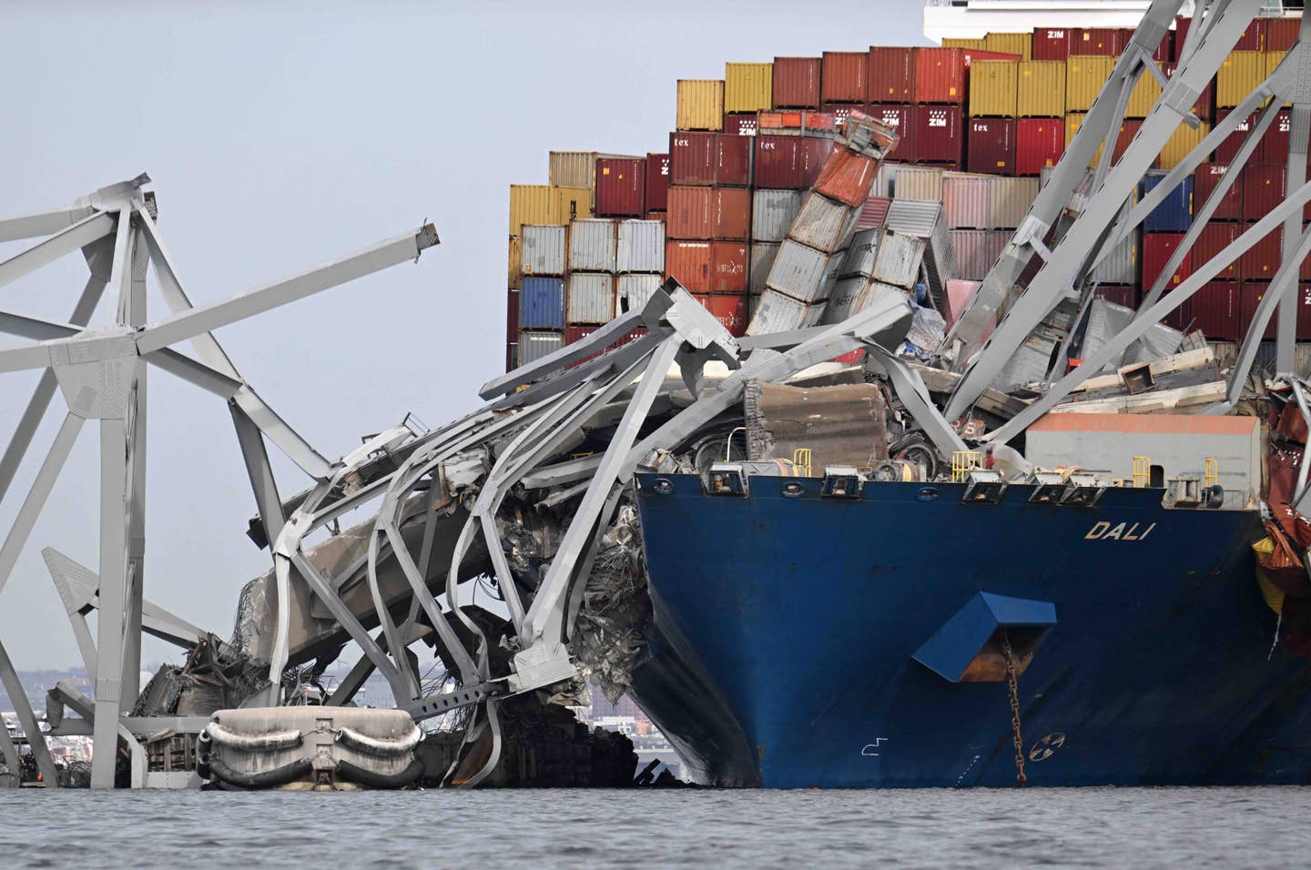The steel frame of the Francis Scott Key Bridge sits on top of the container ship Dali after the bridge collapsed, Baltimore, Maryland, on March 26, 2024. <em>Photo by Jim WATSON / AFP</em>