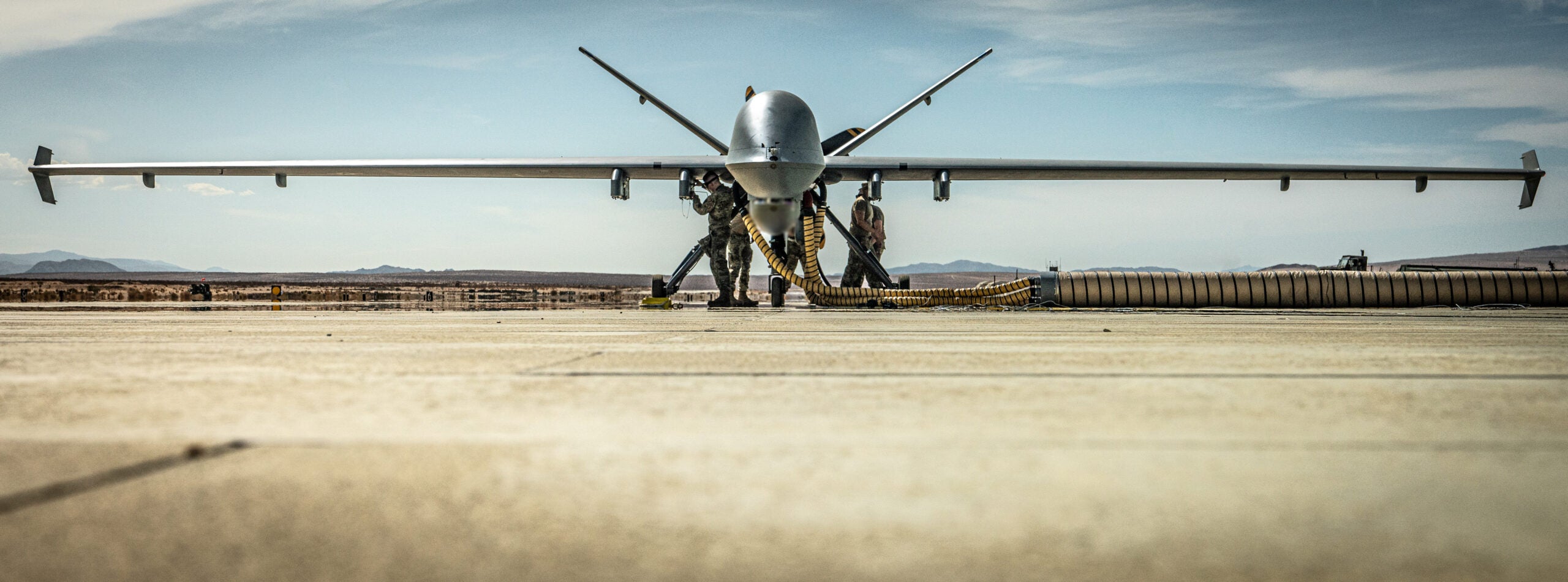 A U.S. Air Force MQ-9 Reaper with the 163rd Attack Wing, California Air National Guard, refuels during Integrated Training Exercise (ITX) 4-22 at Marine Corps Air-Ground Combat Center, Twentynine Palms, Calif., on July 20th, 2022. The MQ-9 Reaper received fuel via aviation delivered ground refueling from an MV-22 Osprey with Marine Medium Tiltrotor Squadron 764, marking the first time the MQ-9 received fuel from a joint asset and the first time an Air National Guard MQ-9 received fuel from another aircraft. The MQ-9 Reaper provided close air support to Marine Air-Ground Task Force 23 during its execution of the fire support coordination exercise of ITX as the Marine Corps Reserve continues to work to integrate with sister services in preparation for future operations. (U.S. Marine Corps photo by. Sgt. Matthew Teutsch)



This photo has been altered for security purposes