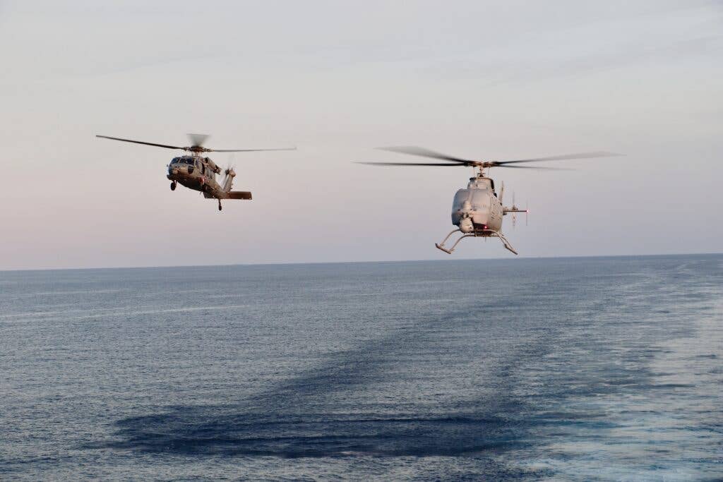 An MH-60S Sea Hawk and MQ-8C Fire Scout unmanned aerial vehicle, assigned to Helicopter Sea Combat Squadron (HSC) 23, conduct concurrent flight operations as a manned-unmanned team (MUM-T) while embarked on the Independence-variant littoral combat ship USS <em>Jackson</em> (LCS-6).&nbsp;(<em>U.S. NAVY / Lt. j.g. Alexandra Green</em>)