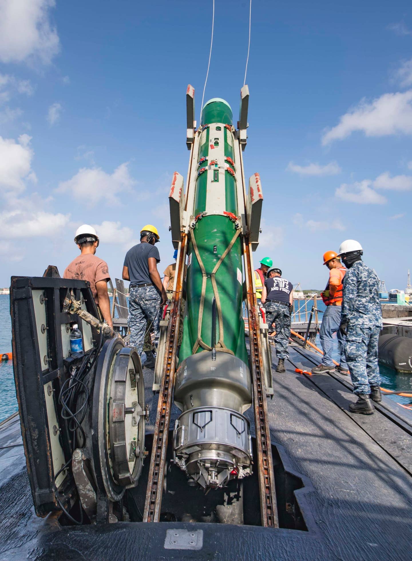 Sailors and Military Sealift Command civilian mariners working from Polaris Point transfer torpedoes to the <em>Los Angeles</em> class fast-attack submarine USS <em>Topeka</em> from the pier, Guam, May 31, 2018.<em> U.S. Navy photo by Mass Communication Specialist 3rd Class Alana M. Langdon/Released</em>