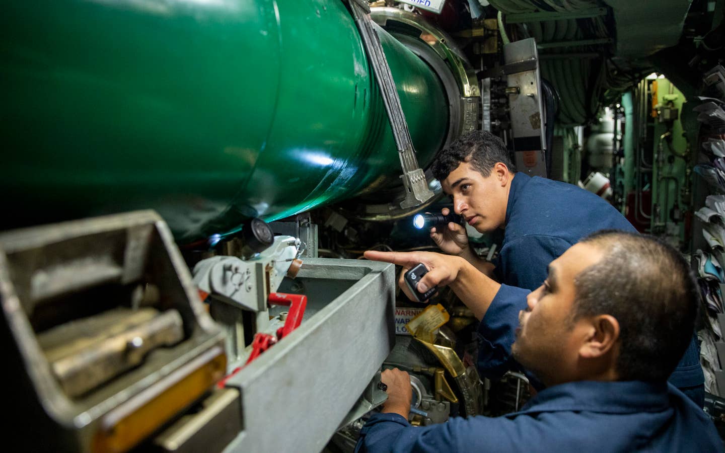 PHILIPPINE SEA (Jan. 26, 2023) – Chief Torpedoman’s Mate Christopher Collado (right), and Sonar Technician Submarines 3rd Class Steven Flores (left), assigned to the Los Angeles-class fast-attack submarine USS <em>Annapolis</em> (SSN 760), conduct torpedo offloading procedures in the torpedo room while underway, Jan. 26. Annapolis is conducting maritime operations in the U.S. 7th Fleet area of operations to maintain a safe and open Indo-Pacific. (U.S. Navy photo by Mass Communication Specialist Seaman Darek Leary)