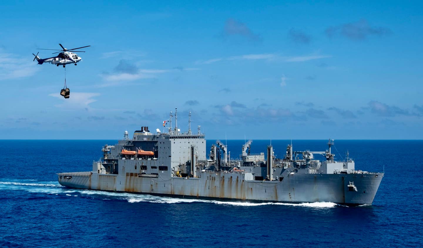 Sailors move cargo onto an aircraft elevator during a vertical replenishment-at-sea with Military Sealift Command dry cargo and ammunition ship, USNS <em>Carl Brashear</em> (T-AKE 7), on the flight deck of the U.S. Navy’s only forward-deployed aircraft carrier, USS <em>Ronald Reagan</em> (CVN 76), in the Philippine Sea, Aug. 19, 2023. <em>U.S. Navy photo by Mass Communication Specialist 2nd Class Caroline H. Lui</em>