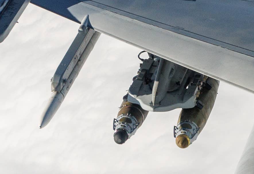 A close-up look at the JDAMs under the right wing of the Bahraini Block 70 F-16D. The example seen on the left in this picture, with the black-colored nose section, is a dual-mode LJDAM type. What looks to be a test pod under the jet's right outboard underwing pylon is also visible here. <em>USAF</em>