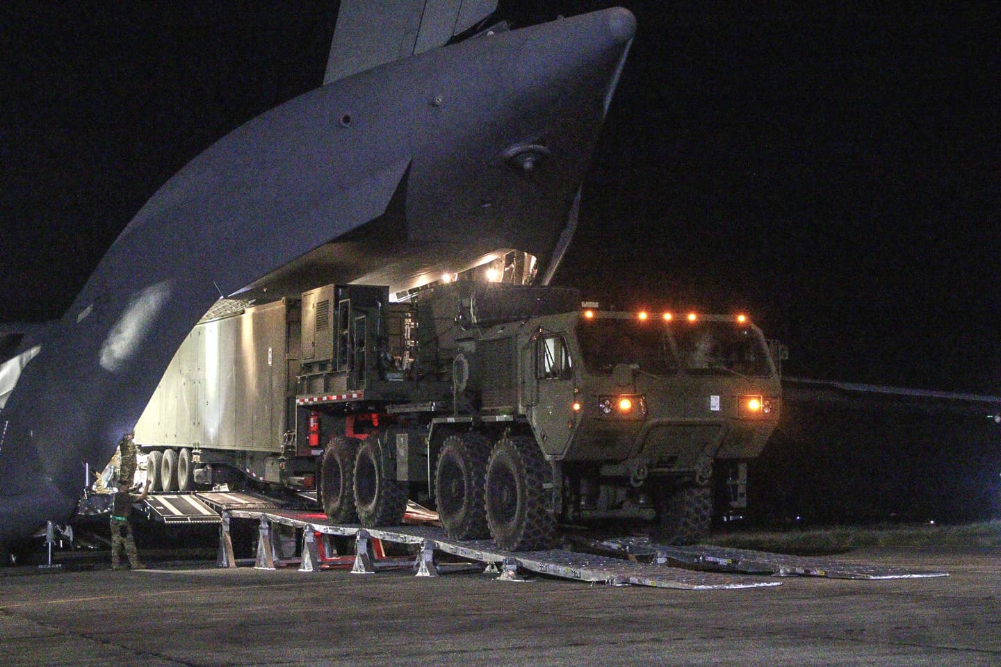 US personnel unload a trailer-based launcher associated with the Typhon weapon system from a C-17A transport plane in the Philippines on April 7, 2024. US Army