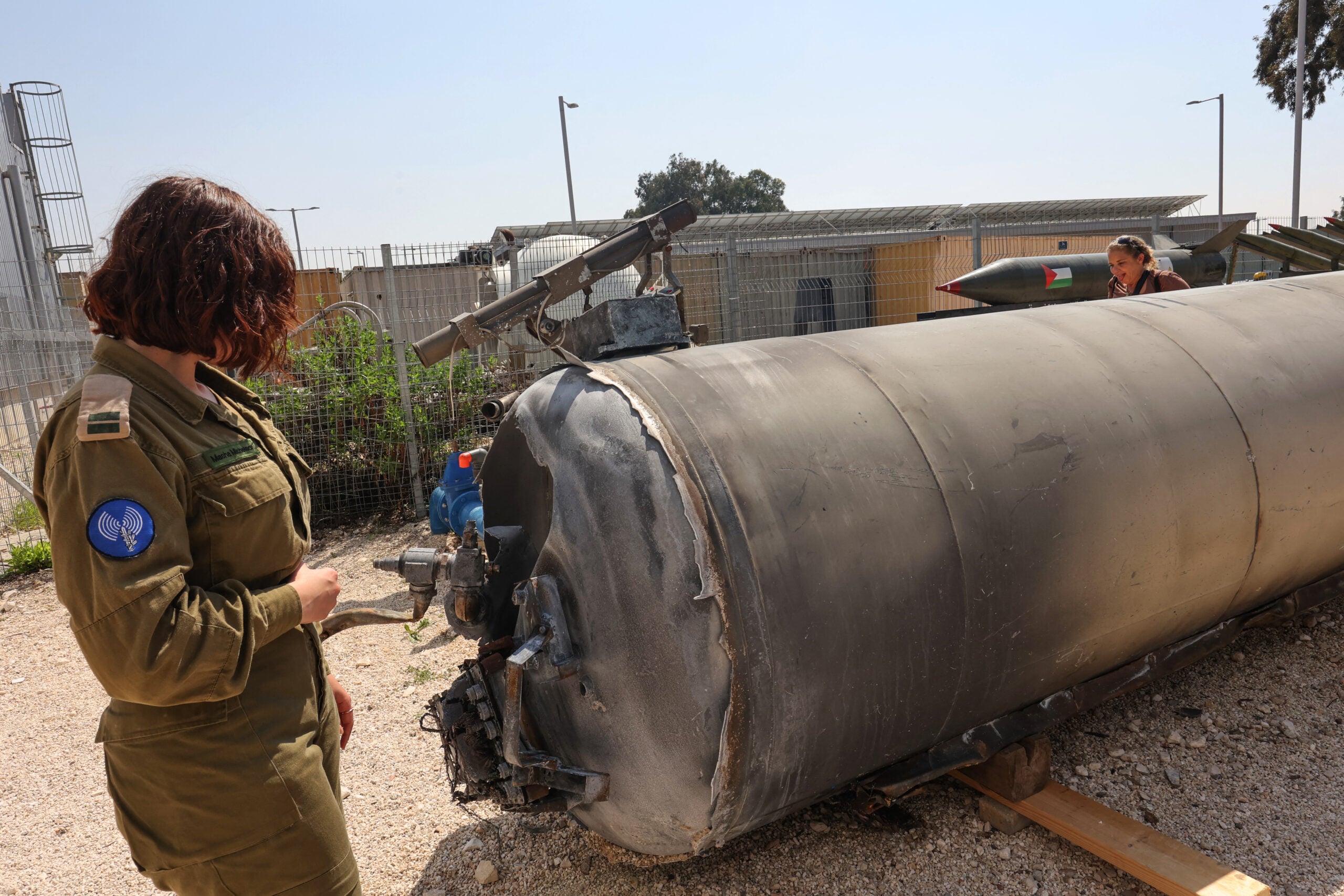 A member of the Israeli military stands next to an Iranian ballistic missile which fell in Israel on the weekend, during a media tour at the Julis military base near the southern Israeli city of Kiryat Malachi on April 16, 2024. Iran carried out an unprecedented direct attack on Israel overnight April 13-14, using more than 300 drones, cruise missiles and ballistic missiles, in retaliation for a deadly April 1 air strike on the Iranian consulate in Damascus. Nearly all were intercepted, according to the Israeli military. (Photo by GIL COHEN-MAGEN / AFP) (Photo by GIL COHEN-MAGEN/AFP via Getty Images)