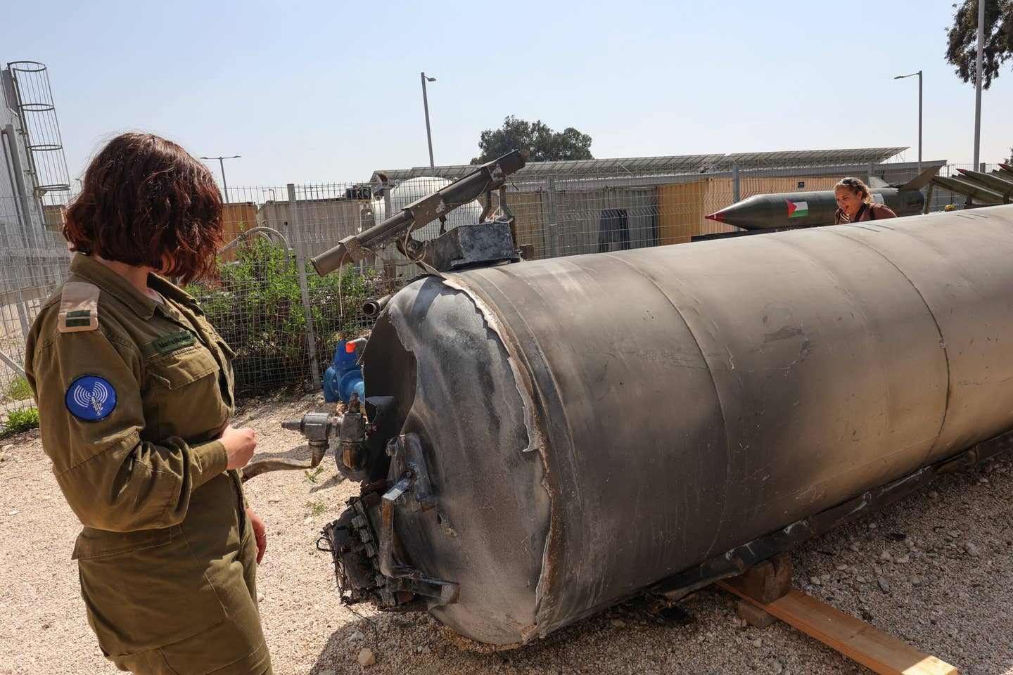 A member of the Israeli military stands next to an Iranian ballistic missile which fell in Israel on the weekend, during a media tour at the Julis military base near the southern Israeli city of Kiryat Malachi on April 16, 2024. <em>Photo by GIL COHEN-MAGEN/AFP via Getty Images</em>