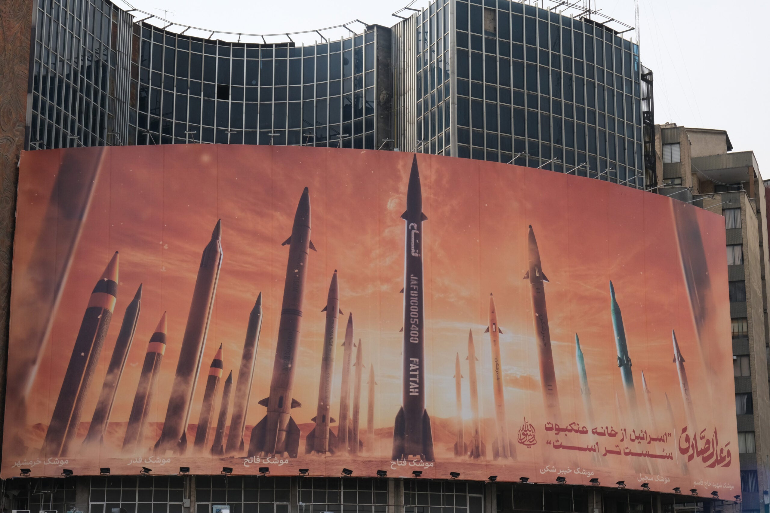 TEHRAN, IRAN - APRIL 16, 2024: A huge banner posted on a building facade in Vali Asr square depicts IRGC (Iranian Revolutionary Guard Corps) multiple missiles models aimed at Israel on April 16, 2024 in Tehran, Iran. Iran suspects Israel of the attack on the consular section of Iranian embassy in Damascus, Syria on April 1 which Israel have neither confirmed nor denied. Between April 13, 14,2024 overnight Iran sent missiles and drones in retaliation of the consular attack, targeting Israel which were mostly intercepted by Israeli forces and international partners. (Photo by Kaveh Kazemi/Getty Images)