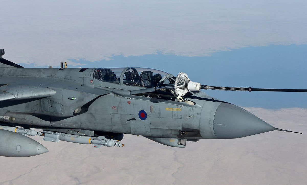 An RAF Tornado GR4 armed with Paveway IV bombs takes fuel from a Voyager tanker during a mission over the Middle East in September 2014. <em>Crown Copyright</em>