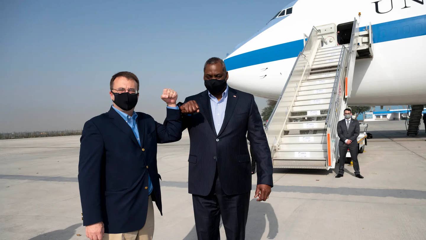 Secretary of Defense Lloyd J. Austin III says farewell to the Chargé d'Affaires of the U.S. Embassy in India, Edgard Kagan, before departing New Delhi, India, on March 20, 2021. An E-4B is seen immediately in the background. <em>DoD/Lisa Ferdinando</em>