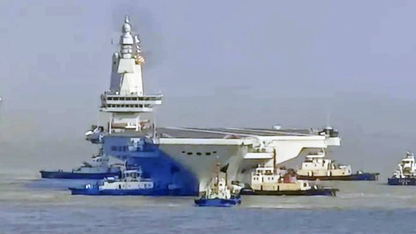 China’s latest aircraft carrier, the Fujian, appears poised to leave port to begin its first at-sea trials. The development comes soon after five aircraft mockups appeared on the deck of the flattop, as you can read about here. Once the Fujian goes to sea, it will mark a hugely important step in the development of China’s naval aviation, with the carrier being the first of its kind to be fully locally designed and also its first to launch aircraft via catapults rather than by a ‘ski jump’ takeoff ramp.