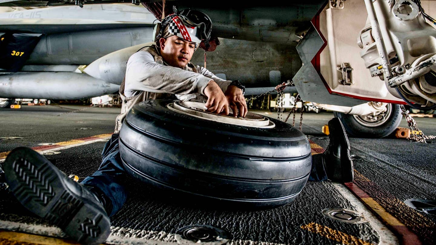 161013-N-OI810-093 WATERS SURROUNDING THE KOREAN PENINSULA (Oct. 13, 2016) Petty Officer 1st Class (AW/SW) John Diwa, from Dededo, Guam, installs inboard and outboard bearings on a main tire mount of an F/A-18F Super Hornet, assigned to the "Diamondbacks" of Strike Fighter Squadron (VFA) 102, in the hangar bay of the Navy's only forward-deployed aircraft carrier, USS Ronald Reagan (CVN 76), during Exercise Invincible Spirit. Invincible Spirit is a bilateral exercise conducted with the Republic of Korea Navy in the waters near the Korean Peninsula, consisting of routine carrier strike group (CSG) operations in support of maritime counter-special operating forces and integrated maritime operations. USS Ronald Reagan is on patrol with CSG 5 supporting security and stability in the Indo-Asia-Pacific region. (U.S. Navy photo by Petty Officer 3rd Class (SW/AW) Nathan Burke/Released)