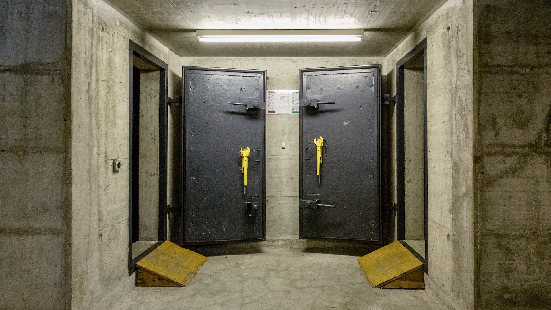 Flourescent light and two metal doors - concrete bunker style. Lausanne Switzerland