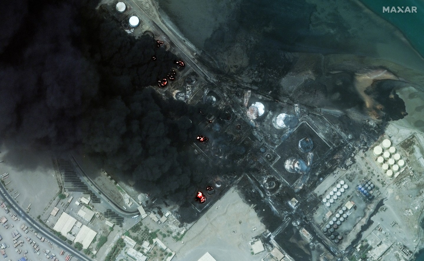 A view of the Yemeni coastline with smoke rising from a port area.
