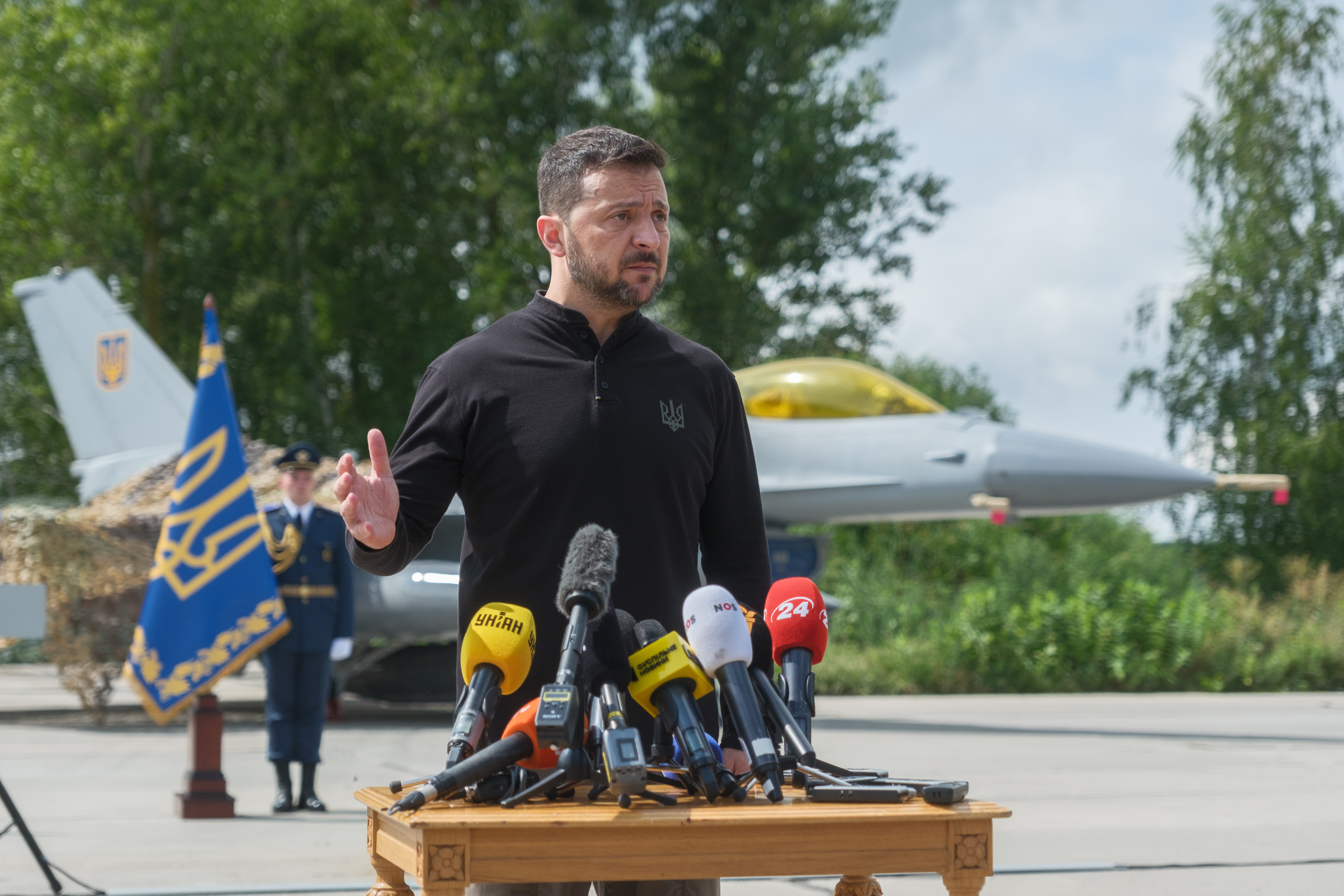 UNSPECIFIED, UKRAINE - AUGUST 4: President of Ukraine Volodymyr Zelenskyi stands in front of the first General Dynamics F-16 Fighting Falcon received by Ukraine as he congratulates Ukrainian military on the Day of Ukrainian Air Force on August 4, 2024 in Unspecified, Ukraine. At the event for the Day of Ukrainian Air Force with the participation of President of Ukraine Volodymyr Zelenskyi, the first General Dynamics F-16 Fighting Falcons received by Ukraine were demonstrated. (Photo by Vitalii Nosach/Global Images Ukraine via Getty Images)