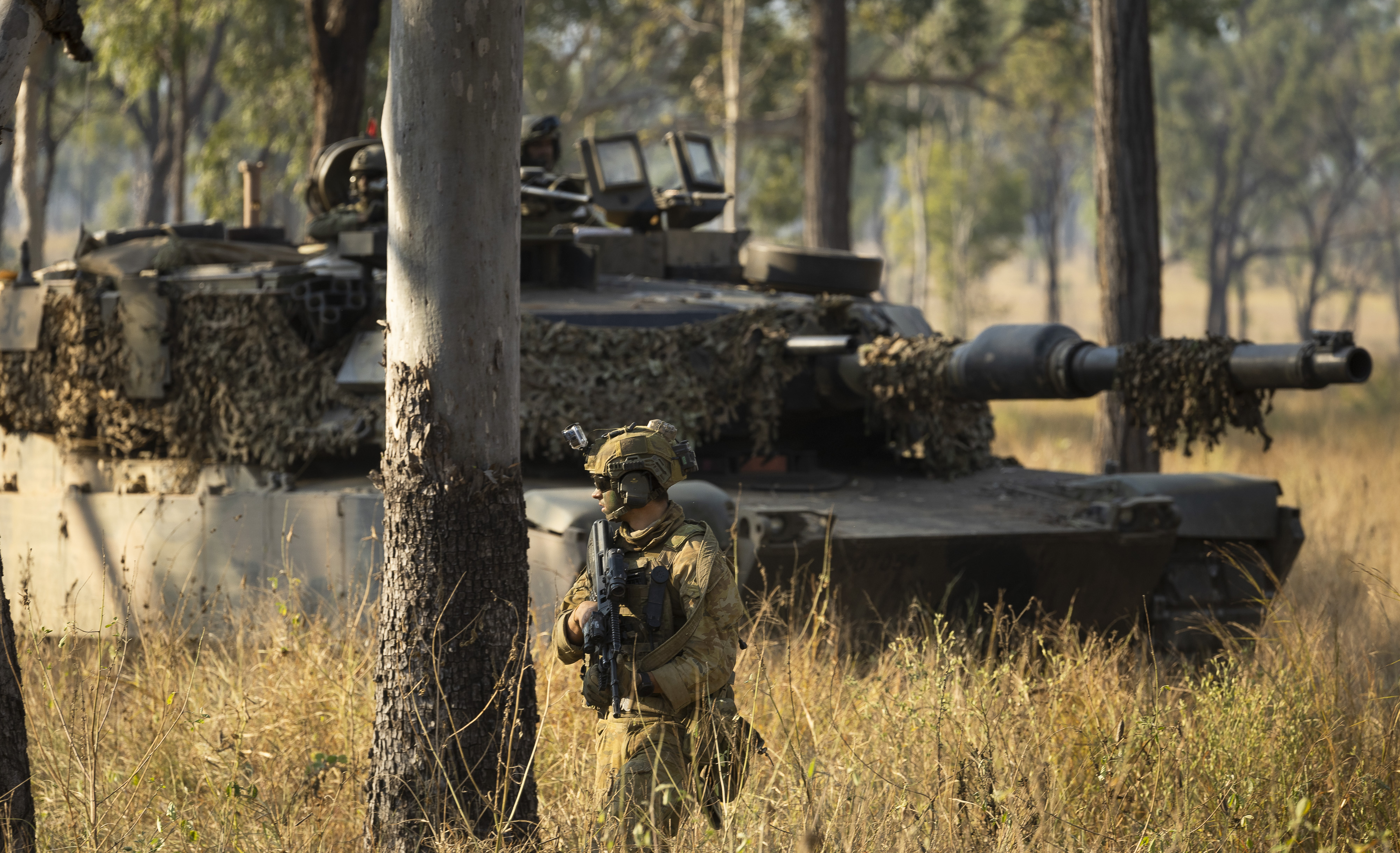An Australian M1A1 Abrams Main Battle Tank from 2nd Cavalry Regiment and an Australian Army soldier from 3rd Battalion, The Royal Australian Regiment during Exercise Brolga Sprint 24 at Townsville Field Training Area, Queensland, on 09 June 2024. *** Local Caption *** Soldiers from the 3rd Brigade conducted Exercise Brolga Sprint at Townsville Field Training Area alongside the United States Army and Marine Corps. Exercise Brolga Sprint 2024 is a combined arms live fire activity where infantry, armour, artillery and combat engineers work together to achieve the mission set. M1A1 Abrams Main Battle Tanks from the 2nd Cavalry Regiment joined the Brigade counter attack as part of the live fire exercise.